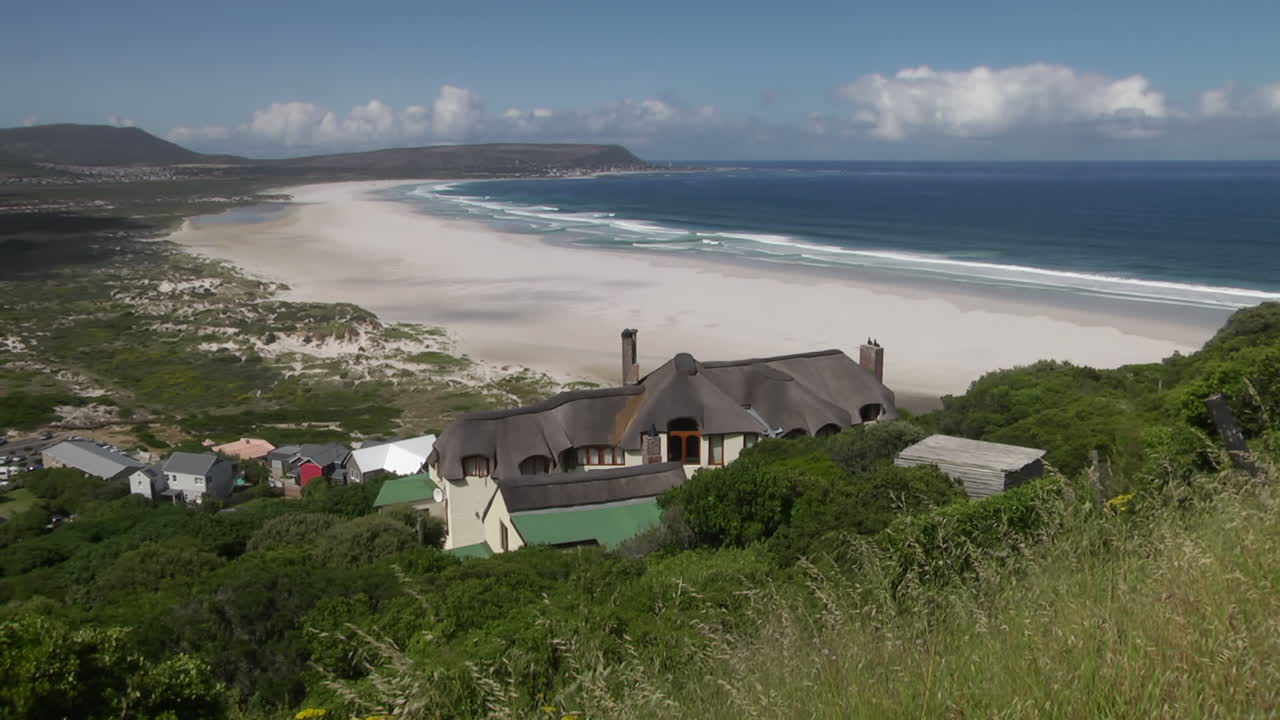 Waves Slowly Breaking On South African Beach Shoreline Viewed From Grassland. Locked Off, Wide Angle