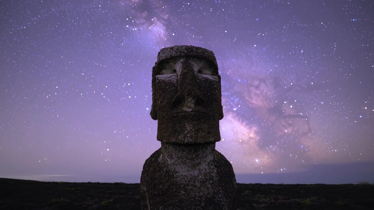 Timelapse che inizia mostrando la telecamera che si avvicina a un monolito su una piana rocciosa di notte, rivelando le stelle.