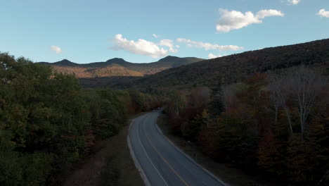 Aerial-rising-New-England-highway,-mountains,-and-fall-foliage