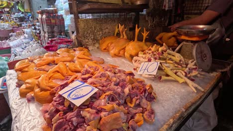 vendor arranging chicken at a busy market stall