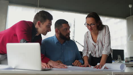 equipo de negocios sonriente trabajando en la mesa y mirando a la cámara