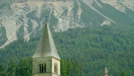 focus shot, scenic view of top of church tower in italy, rocky mountain range of melcesine in the background