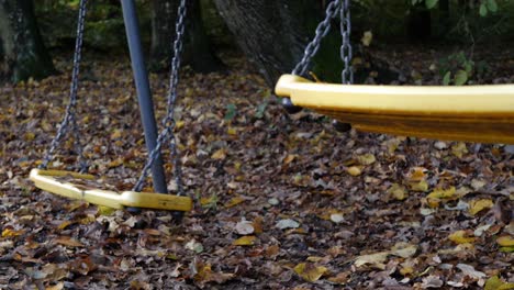 Closeup-of-empty-swing-set-moving-by-itself