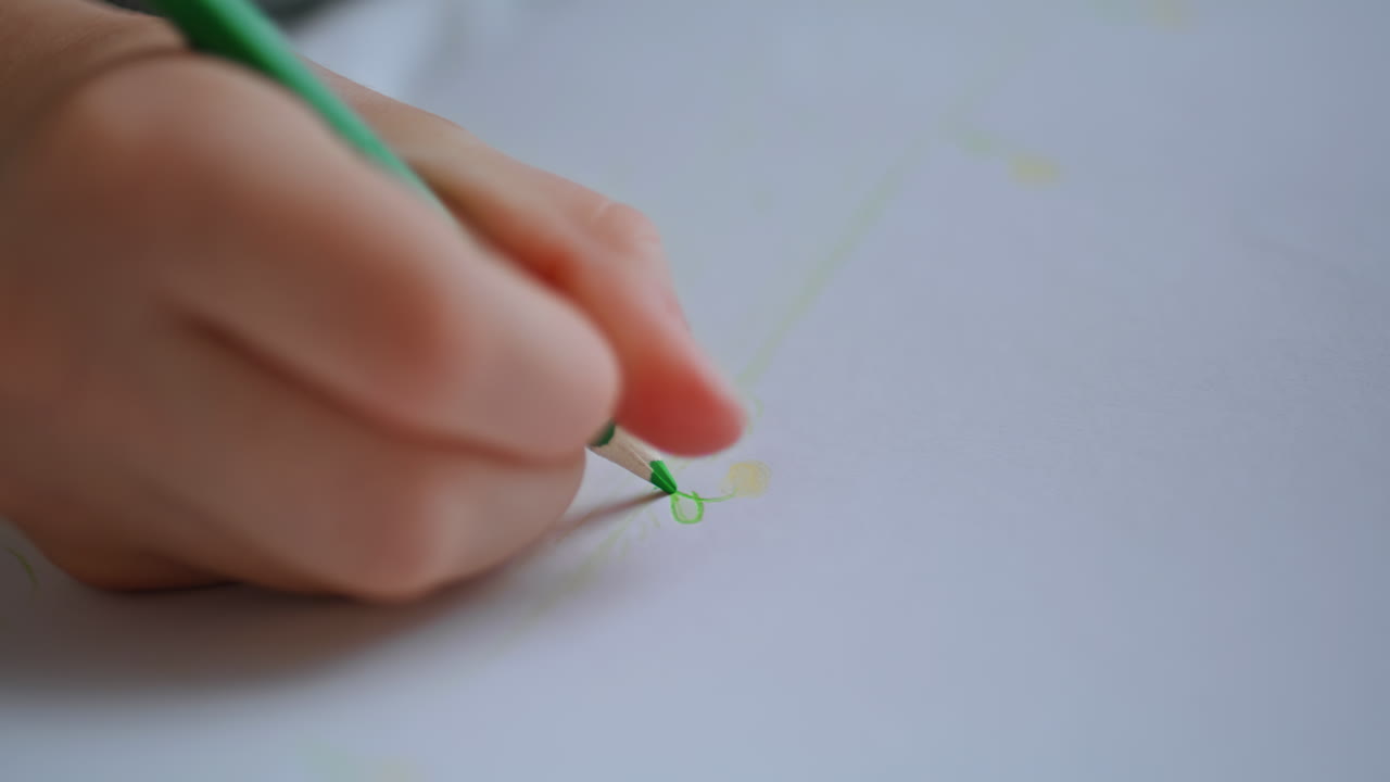 Toddler hands coloring picture sitting indoors closeup. Little girl painting