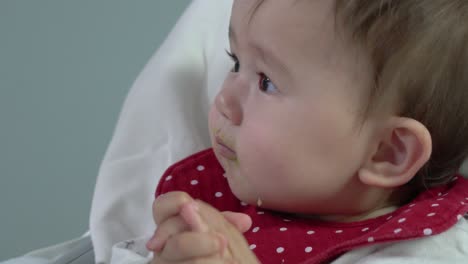 bebé se niega a comer aguacate de una cuchara súper primer plano