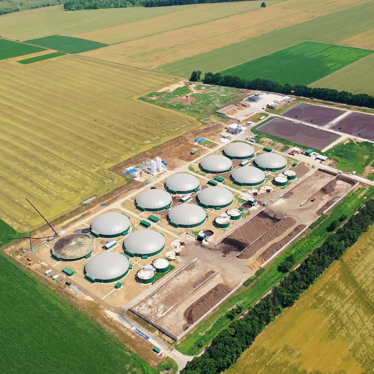 Biogas complex. Round storage tanks for production biomass. Innovative manufacturing on field. View from above