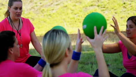 Female-trainer-instructing-women-while-exercising-during-obstacle-course