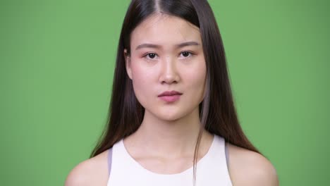 young beautiful asian businesswoman with finger on lips