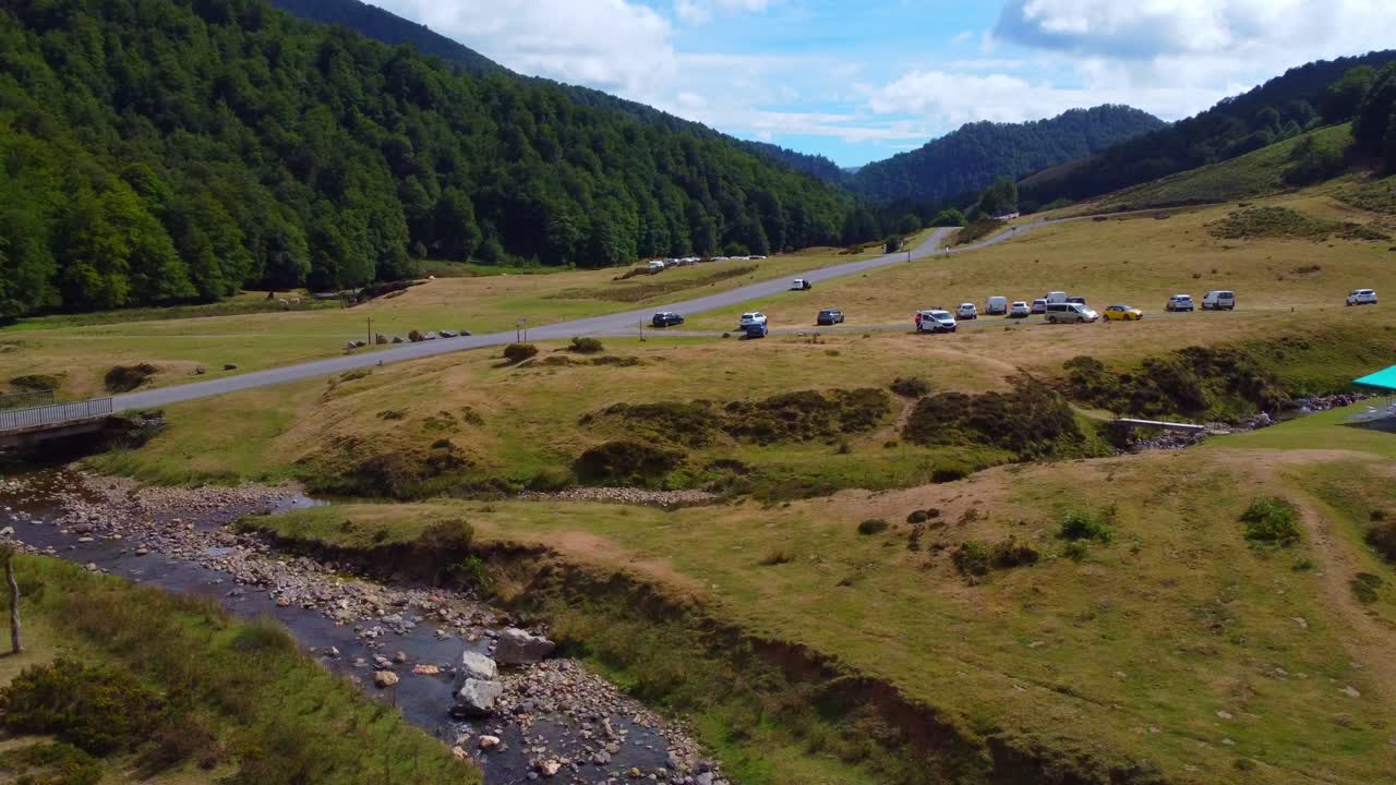 Parcheggio di montagna nei Pirenei, Francia. Ripresa aerea che si addentra in una valle molto lussureggiante, nuvole spettacolari