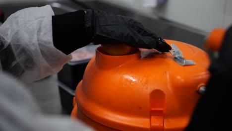 trabajador que filtra tomates en la prensa de tomates, preparación de alimentos