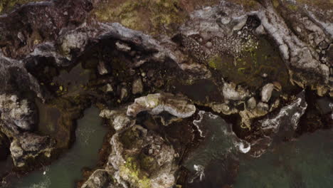 iceland's rocky cliffs on beautiful ocean coastline - aerial top down view