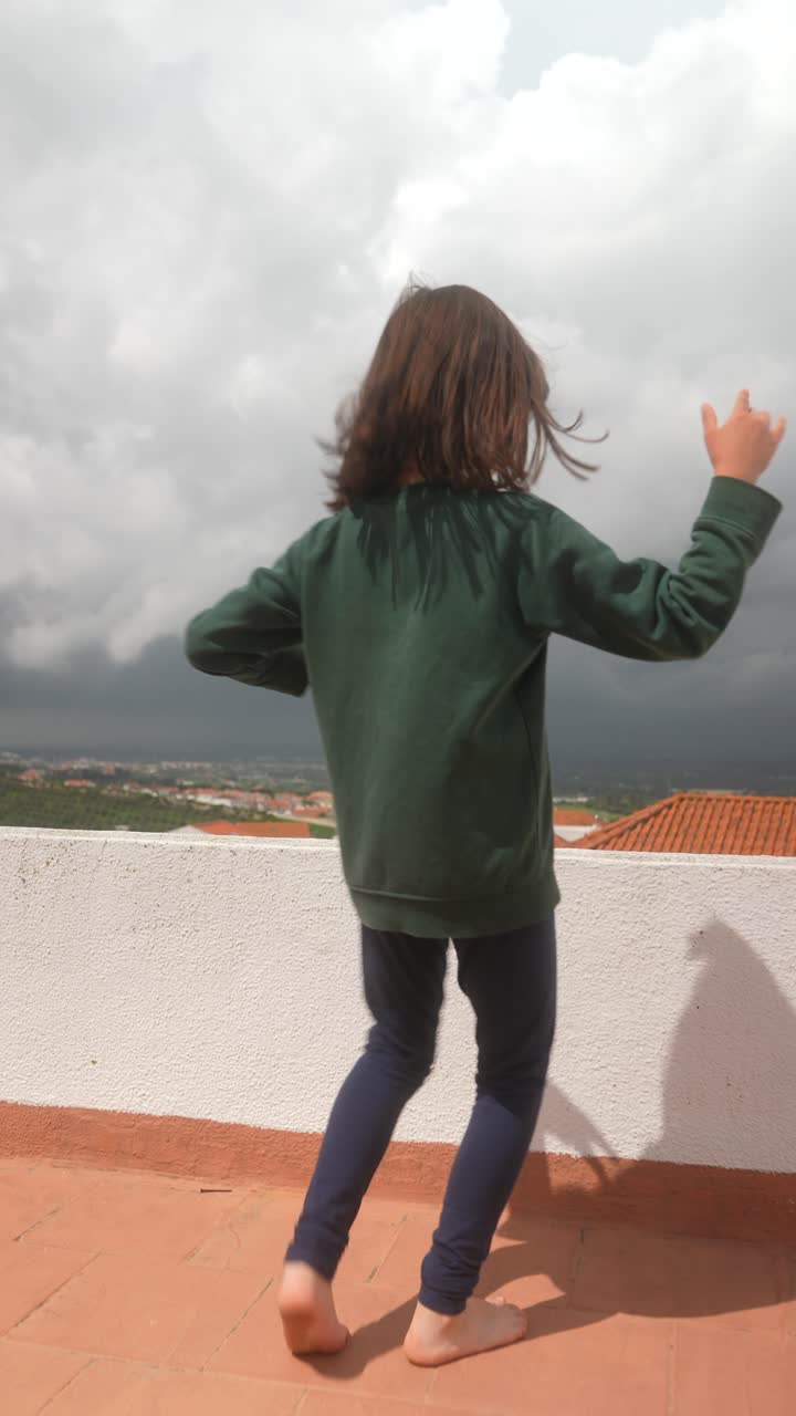 Girl Dancing on a Rooftop During Cloudy Weather