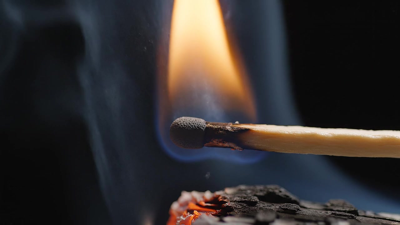 Macro shot of a lit matchstick with vibrant flame
