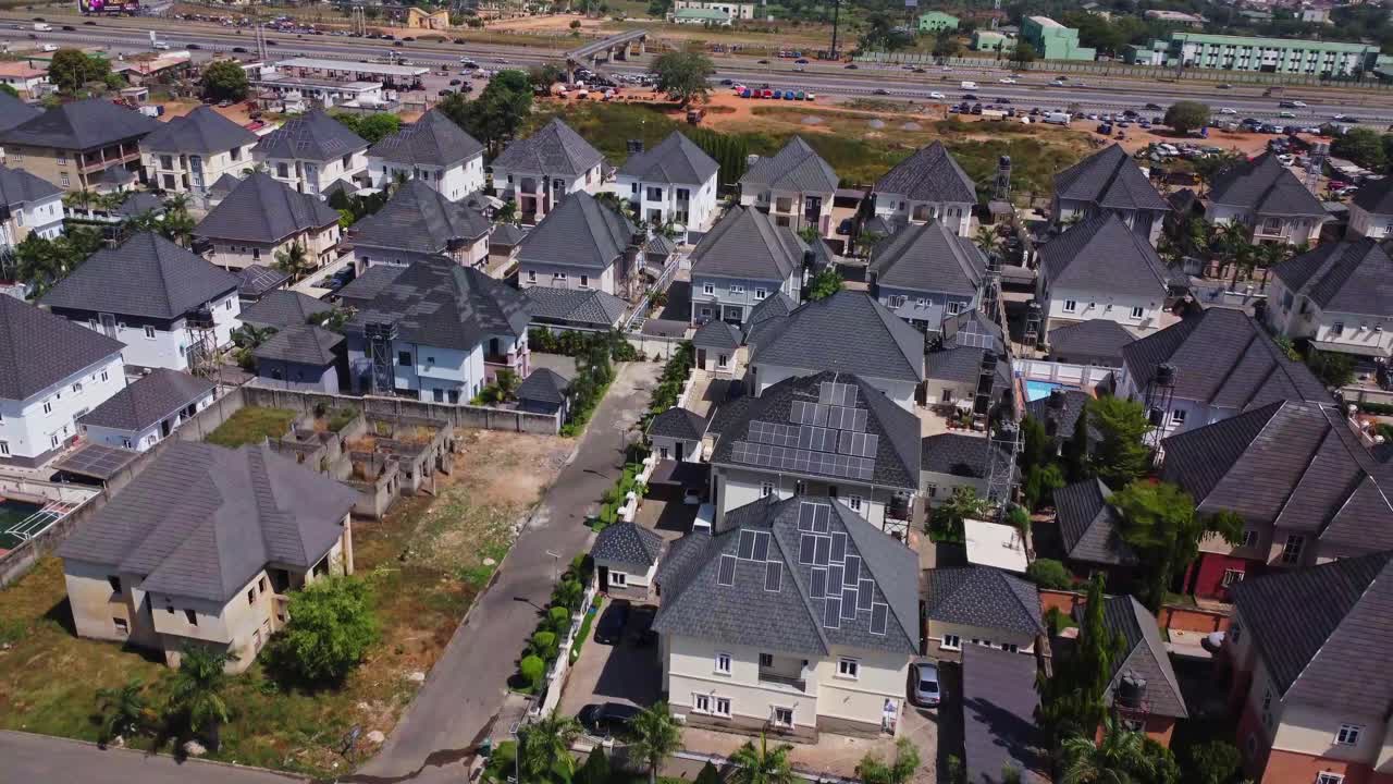 晴れた日のナイジェリア、アブジャにある新築の郊外住宅地の美しい空撮。屋根には太陽光発電パネルが設置された豪華な家々が立ち並ぶ