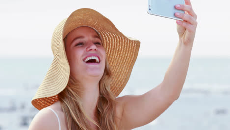 una hermosa rubia sonriente tomando una selfie