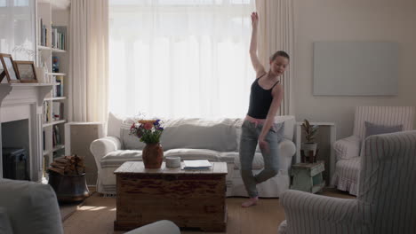 beautiful teenage girl dancing at home practicing ballet dance moves having fun rehearsing in living room