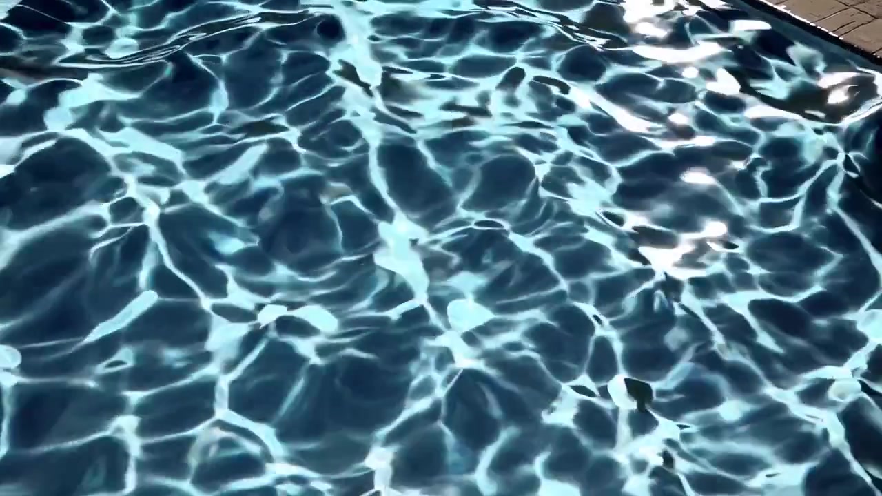 Sinar Matahari Berkilauan dan Memantul di Air Kolam Renang Biru