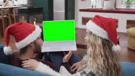 Happy-caucasian-couple-having-christmas-laptop-video-call-with-green-screen,-slow-motion