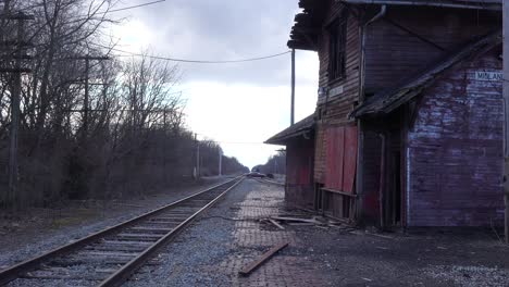 an old abandoned railways station platform and empty rail line railroad track in distance suggests lonely places