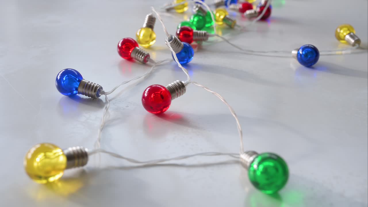 en una superficie blanca, un conjunto de luces de navidad en diferentes colores en azul, rojo, amarillo y verde