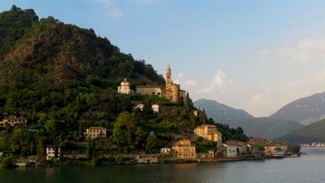 disparo de drones girando alrededor de la chiesa di santa maria del sasso en suiza volando sobre el lago de lugano