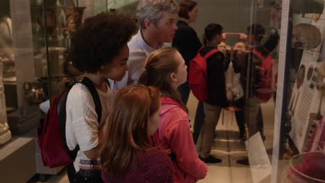 students look at objects in cases on museum trip shot on r3d