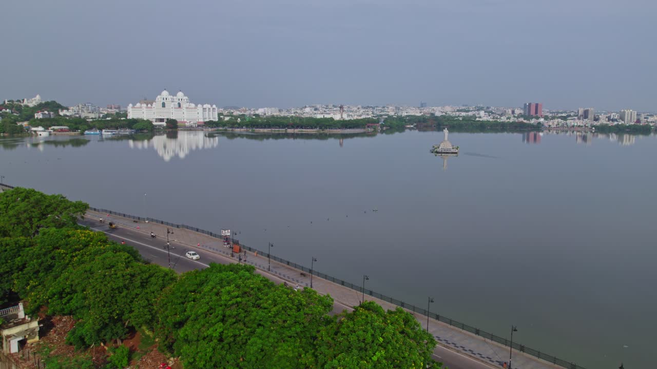 aerial view of tank bund with status, buildings and Telangana Secretariat reflections on water at hussain sagar lake, khairtabad, hyderabad, india. day time, static shot, drone shot, 4k.