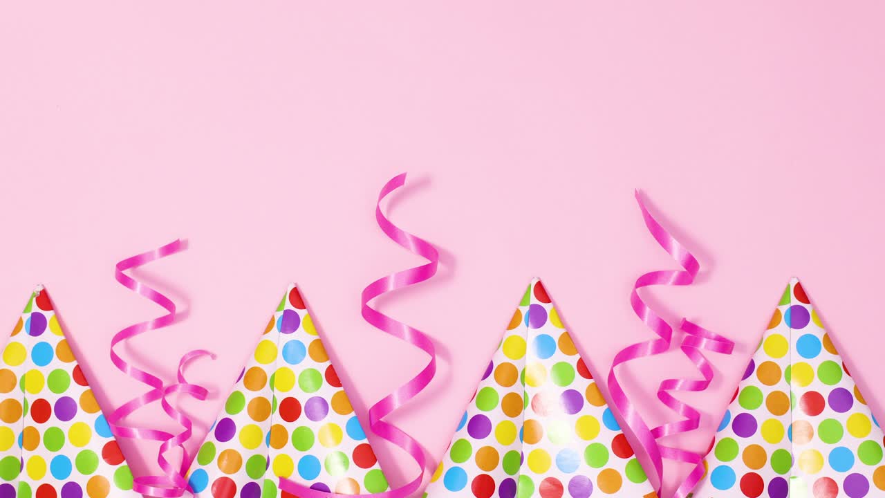 Party caps and pink ribbons appear on bottom of pastel pink theme. Stop motion