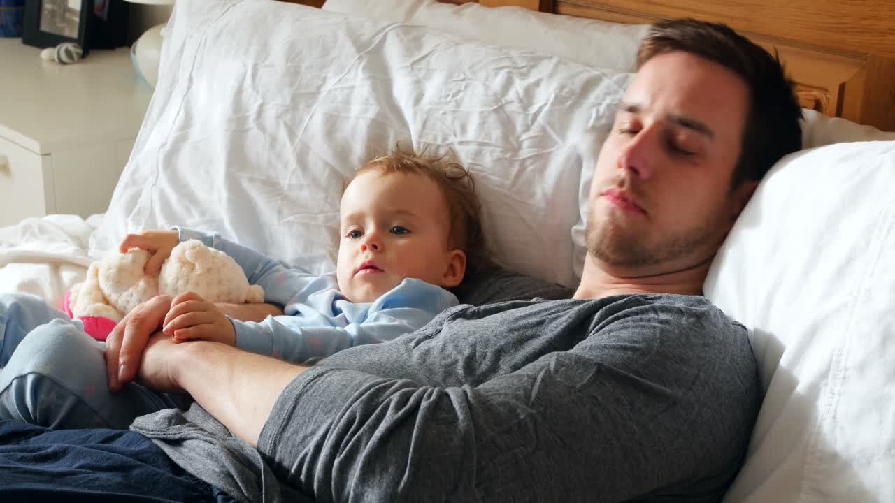 아버지와 아기 소년은 침실 4k에서 휴식을 취하고 있습니다.