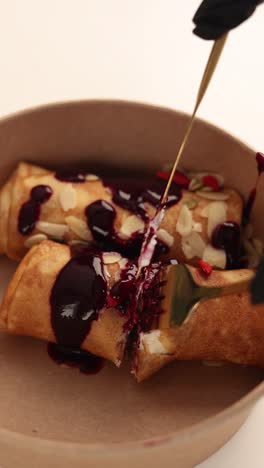deliciosas crepes enrolladas con salsa de bayas