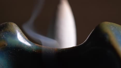 macro shot of aromatic smoke over blue ceramic backflow incense burner