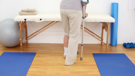 Injured-patient-in-crutches-walking-away-from-camera