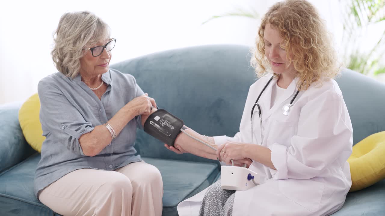 Doctor Checking Senior Woman's Blood Pressure at Home