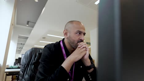 el individuo está sentado en el interior, participando en el aprendizaje digital y la observación a través de una amplia pantalla