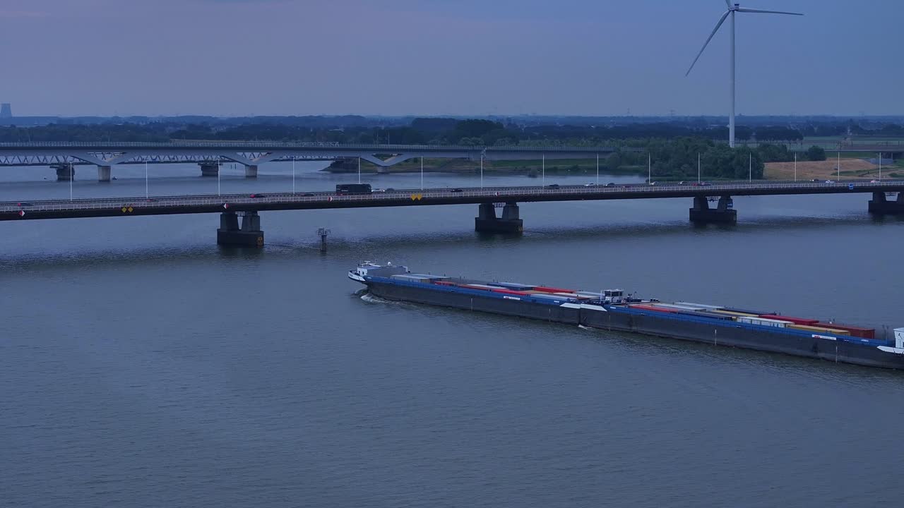 컨테이너 를 들고 있는 화물 선박 이 바쁜 다리 아래 를 지나간다