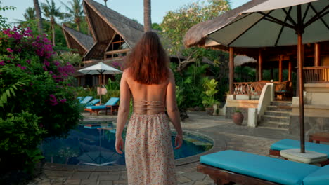 Stylish-elegant-woman-wandering-through-luxurious-holiday-resort-facility