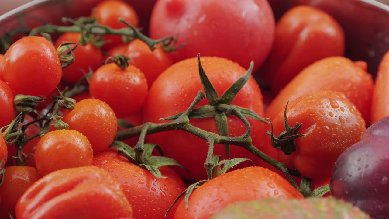 Colorful organic tomatoes. Mix tomatoes background, Several varieties of sliced tomatoes top view. Different assorted colorful tomatoes, heirloom, cherry, rose, beefsteak, cocktail, grape, purple.