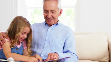 Grandfather-and-granddaughter-looking-a-book-together