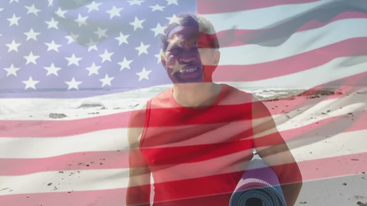 animación de la bandera de los estados unidos de américa y un hombre biracial con una alfombra de yoga en la playa.