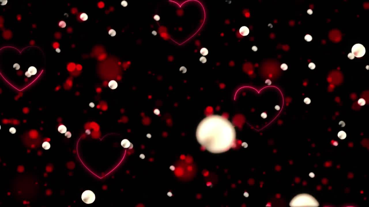 animación de un corazón rojo que cae y manchas brillantes sobre un fondo negro