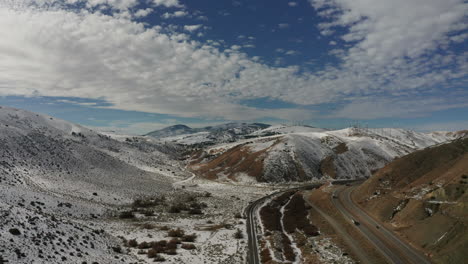 aerial view of cars driving on highway in snowy california mountains