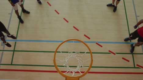 overhead view of african american male basketball player scoring goal against diverse players