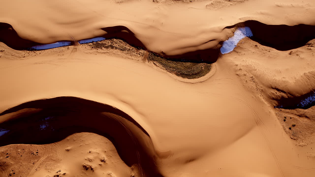 Aerial view directly above the colorful, uniquely shaped pink sand dunes of southern Utah.