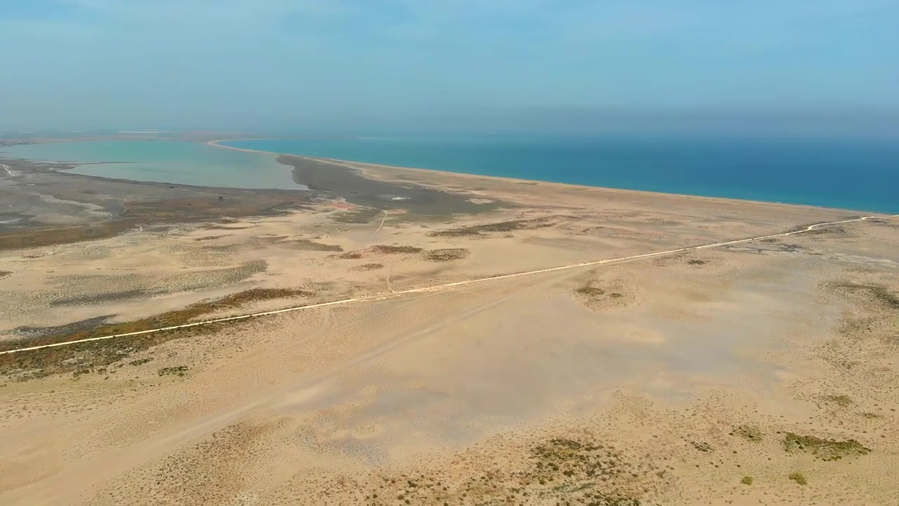 Luftfoto af et vidtstrakt ørkenlandskab, der møder havet