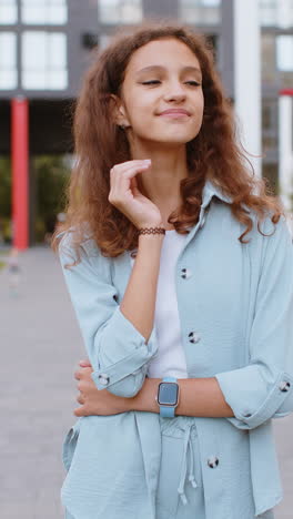 feliz niña adolescente sonriendo mirando hacia otro lado soñando descansando buenas noticias sentirse satisfecho en la calle de la ciudad