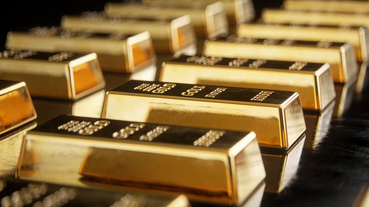 Telecamera che scorre in avanti rivelando lingotti d'oro stampati su una superficie nera lucida per annunci finanziari