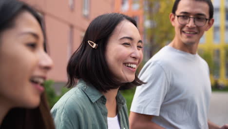 group of three young japanese friends talking and walking together outdoors 1