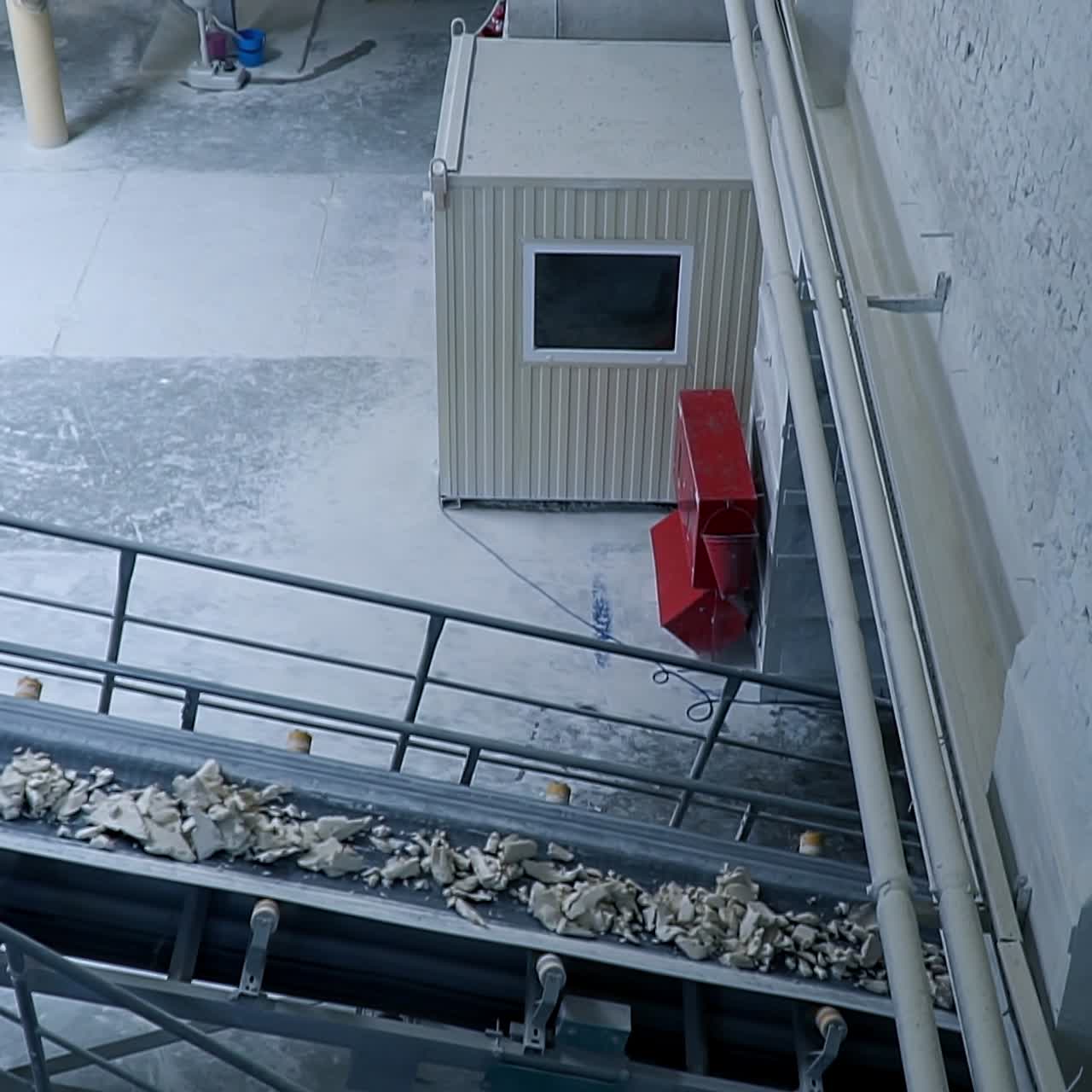 Metal constructions and equipment at industrial plant. Conveyor lines delivering rocks of white clay
