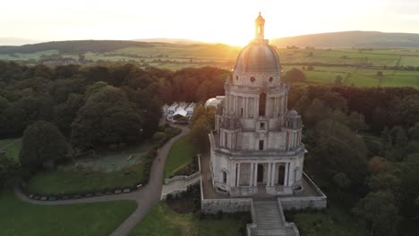 Historic-Ashton-memorial-English-domed-folly-landmark-Lancashire-countryside-sunrise-Aerial-view-orbit-slow-left