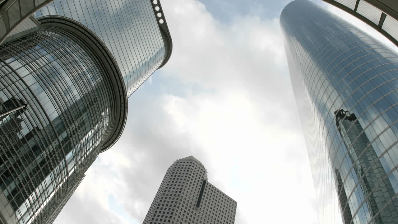 panorámica ascendente lenta de los edificios de la compañía petrolera de houston vistos desde debajo de un arco